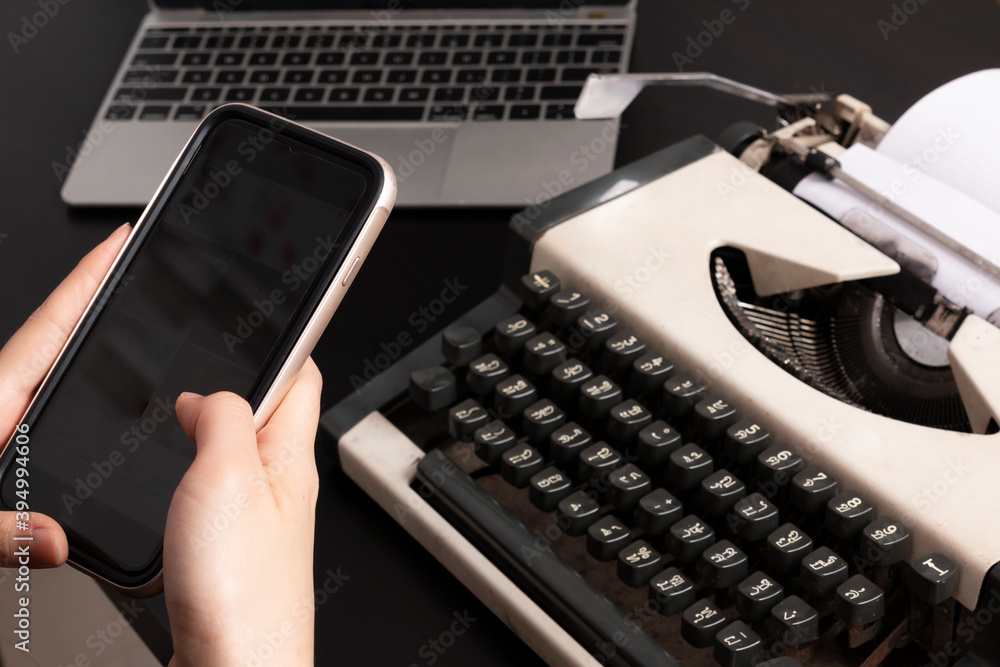 Fototapete concept of technology progress. women using a smartphone with an old thai typewriter and notebook av