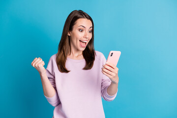Photo of charming pretty young girl hold telephone fist raised excited look yell hooray win biggest...