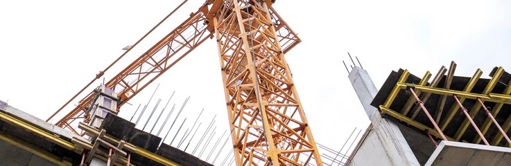 Construction crane stands on the background of the sky. Construction site. Tower crane. Banner.