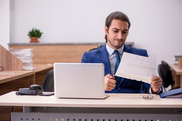 Young male employee burning papers in the office