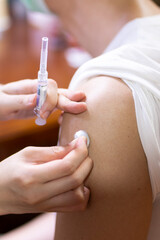 Doctor giving an injection to a male patient in the arm. Vaccine or flu shot in injection needle. Physician or nurse giving vaccination and immunity to virus, influenza or HPV, Covid 19, with syringe.