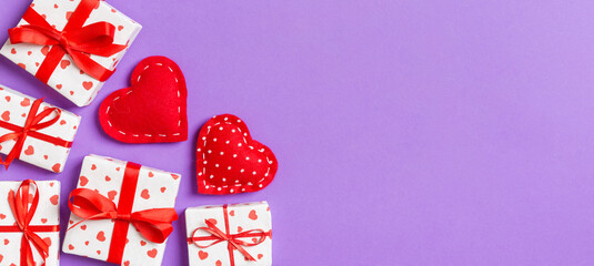 Top view colorful valentine background made of gift boxes and red textile hearts. Valentine's Day concept with copy space