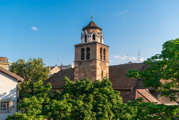 Naklejka premium Geneva, Switzerland. View of the clock tower of Temple of the Madeleine against the background of roofs and trees.