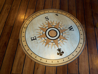 Compass directions wind rose on a wooden floor of a boat