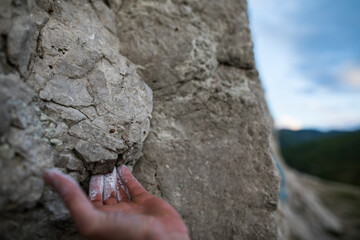 Adult male handholding on to a rock
