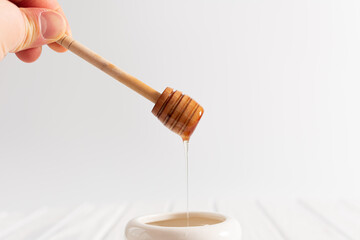 White Jar with honey on a white background. Honey spoon in jar. Jar with honey. Honey spoon