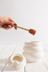 White Jar with honey on a white background. Honey spoon in jar. Jar with honey. Honey spoon