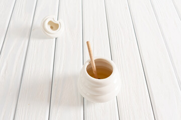 Fototapeta na wymiar White Jar with honey on a white background. Honey spoon in jar. Jar with honey. Honey spoon