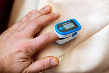 pulse oximeter on a man's finger. Measurement of oxygen in the blood.
