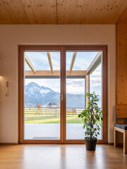 View of the mountain through the door into the garden with wooden glass terrace roofing