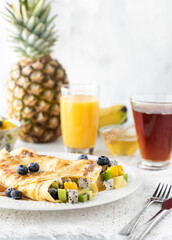 Exotic tropical fruit crepes against a bright background with copy space to the upper right.