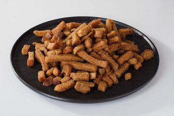 croutons with garlic on a round plate, beer snack isolated on white background
