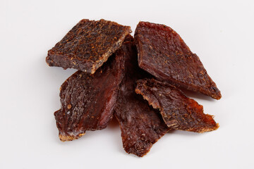 pieces of dried pork with spices, snacks for beer isolated on white background