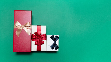 Close-up of three gift boxes on green background with copy space.