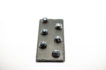 Author's sweets for a holiday, wedding, birthday, anniversary. Black candies on a white background in the studio.