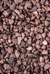 Top view of granite red tone gravel. Small colorful stone composition with space for text. Many different tiny rocks with view from above.. Creative vintage background with copy space