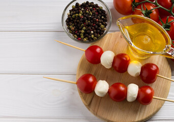 Italian caprese salad with mozzarella balls and tomatoes, on wooden background