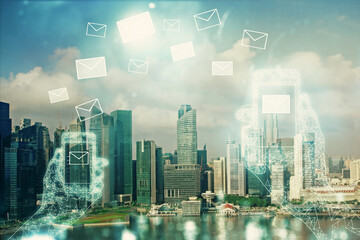 Double exposure of envelop hologram flying from gadget and city view background. Concept e-mail.