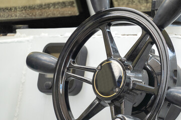 Cut-off image of the steering wheel on a motor boat. Selective focus. © ROMAN DZIUBALO