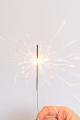 Obraz premium Bengal fire in hand. Hand holds burning sparkler symbol of magic at Christmas. Sparklers in hands, close up