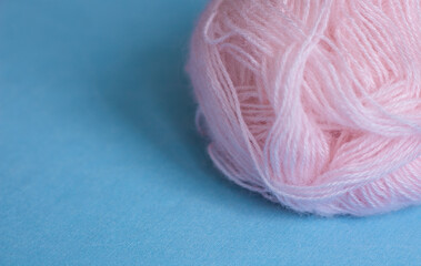 Fototapeta na wymiar Pink ball of yarn on a blue background