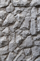 Masonry wall texture. Black grey stones and rocks of different shape, dark grey background, texture for interior and exterior design, vertical format banner