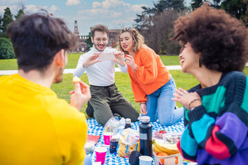 Four cheerful friends diverse multiethnic having fun doing pic nic
