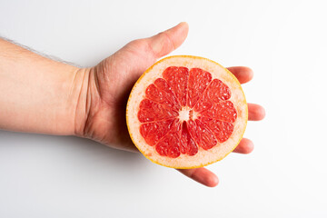 Fresh tasty grapefruit on plate. Half of grapefruit on white background