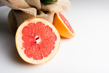 Fresh tasty grapefruit on plate. Half of grapefruit on white background