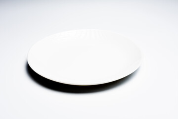 White plate with cutlery on white background
