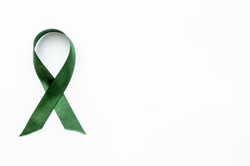 Green awareness ribbon- children mental health lymphoma kidneys cancer awareness symbol. Top view