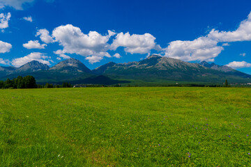 rural fields near Tatra Mountains in summer time. beautiful panorama of agricultural area. gorgeous mountain ridge with high rocky peaks