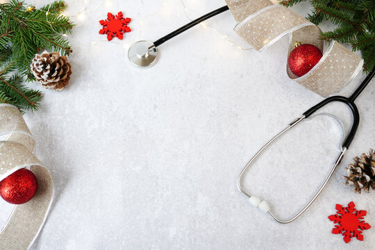 Medical Christmas and New Year. Stethoscope and red christmas decorations on white background with copy space
