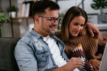 Happy young couple with laptop at home..