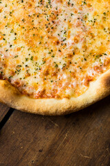 A part of a margherita pizza on a vintage wood surface