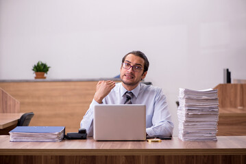 Young male employee unhappy with excessive work in the office