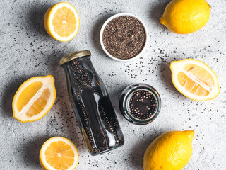 Detox activated charcoal black chia water or lemonade with lemon. Two bottle with black chia infused water. Detox drink idea and recipe. Vegan food and drink. Top view.