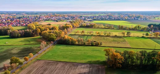 Gardinen Aerial view of the flat landscape in the north of Germany with a village in the background against the straight horizon © Frank