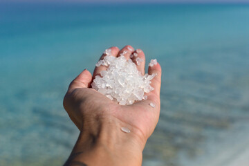 Fototapeta na wymiar Close-up woman hand with white Dead Sea salt crystals, natural mineral formation at the Dead Sea
