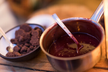 A pot of sauce and a bowl of some brown food.