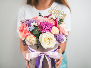 Beautiful bouquet with different flowers in woman hands. Bouquet with roses, dianthus, carnation bush, limonium, lilac and tulip. Shallow DOF, copy space. Top view.