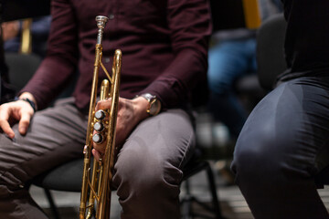 Fototapeta premium A person sitting during a rehearsal and holding a piston trumpet