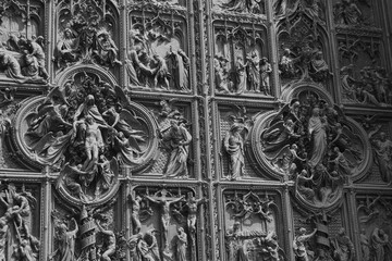 Details of decorations and bronze statues of the entrance door of the Dome of Milan