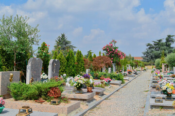 Narrow dirt path with side graves in the cemetery