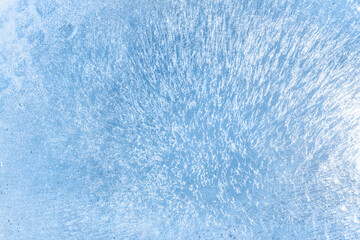 Frozen water, sea. Frosty winter texture of thin ice with glare from the bright sun.