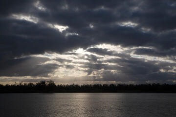 Rays of sun through dark clouds;  Biesbosch Natioanl Park, North Brabant, Netherlands