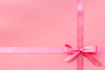 Festive pink ribbon with bow for holiday gift box or greeting card. Top view