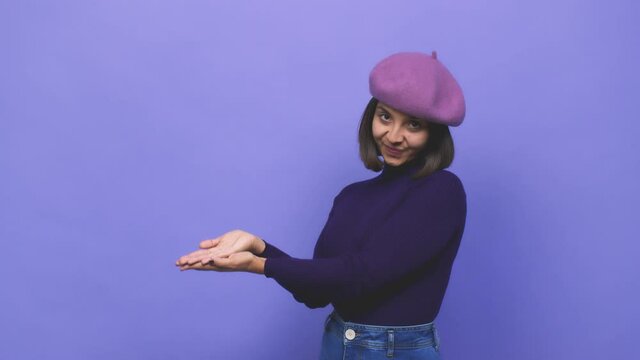 Young latin girl wearing a purple beret holding a copy space on a palm