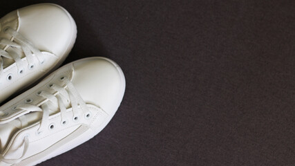 White sneakers on a dark background. top view, lifestyle.Sport. Place for text