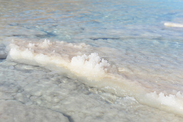 Fototapeta na wymiar Texture of Dead Sea. Salty sea shore background. Salt accumulation on the Dead Sea shore in Jordan